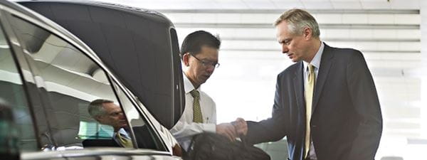 Business traveller getting in to car