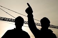 Silhouettes of two men on worksite